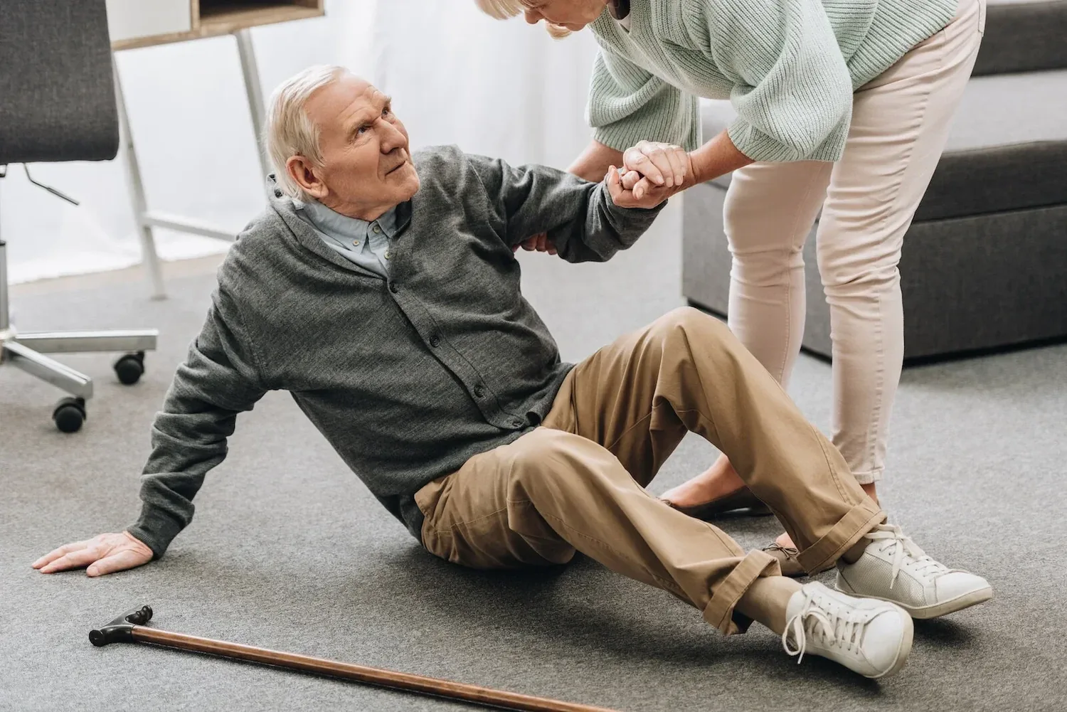 A carer helping an older person to stand after a fall